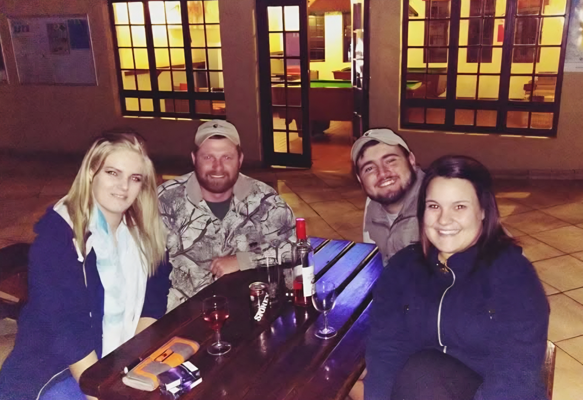 Friends seated together around an outdoor table at night