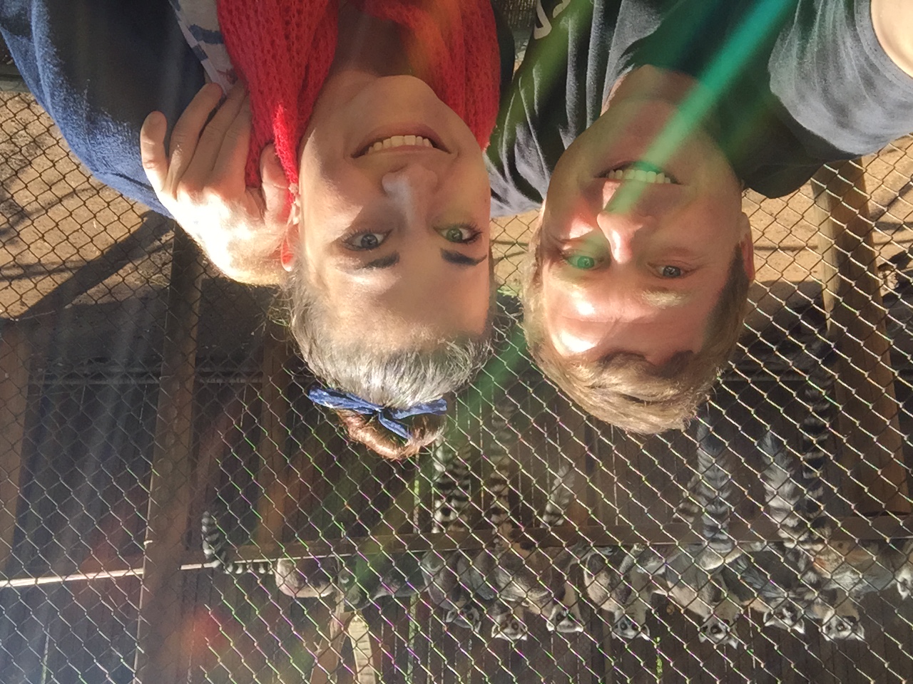 Angelo and Lezita smiling together beside a lemur enclosure