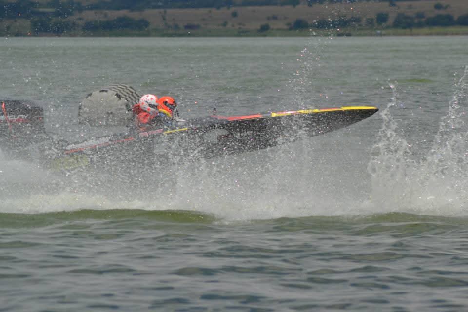 The number 21 boat charging through a burst of spray on the lake