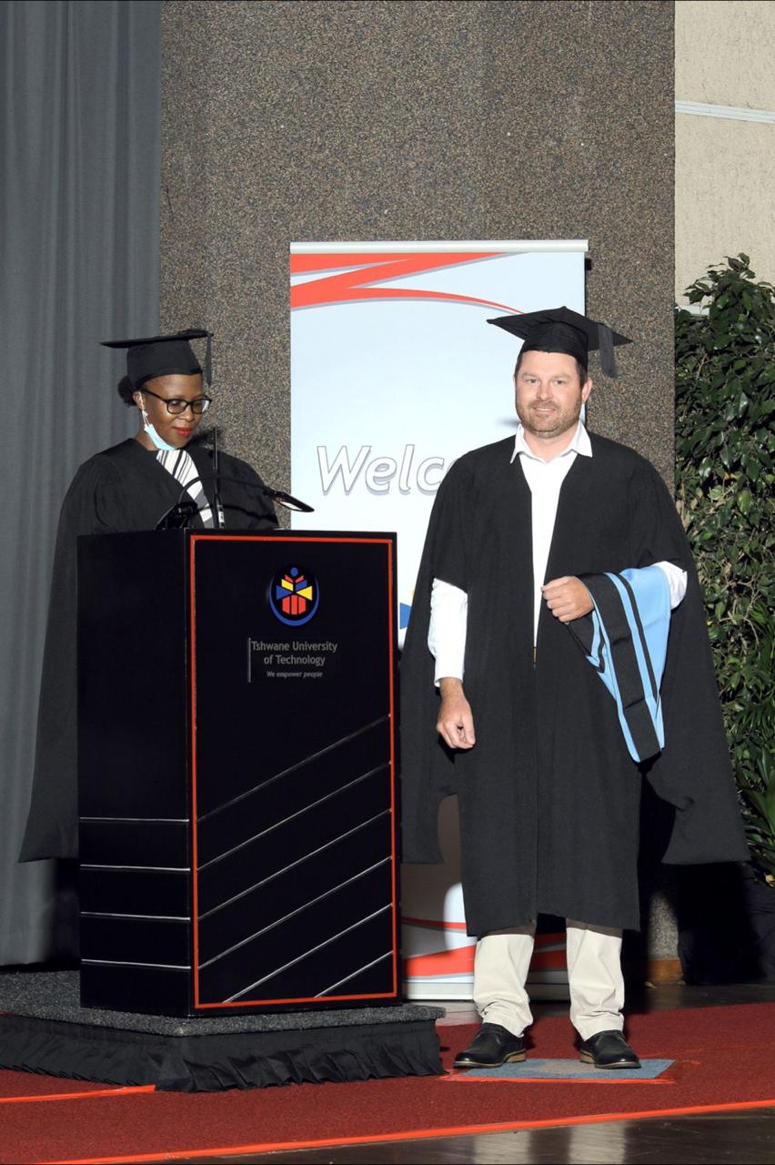 Angelo in graduation gown on stage at his Tshwane University of Technology ceremony