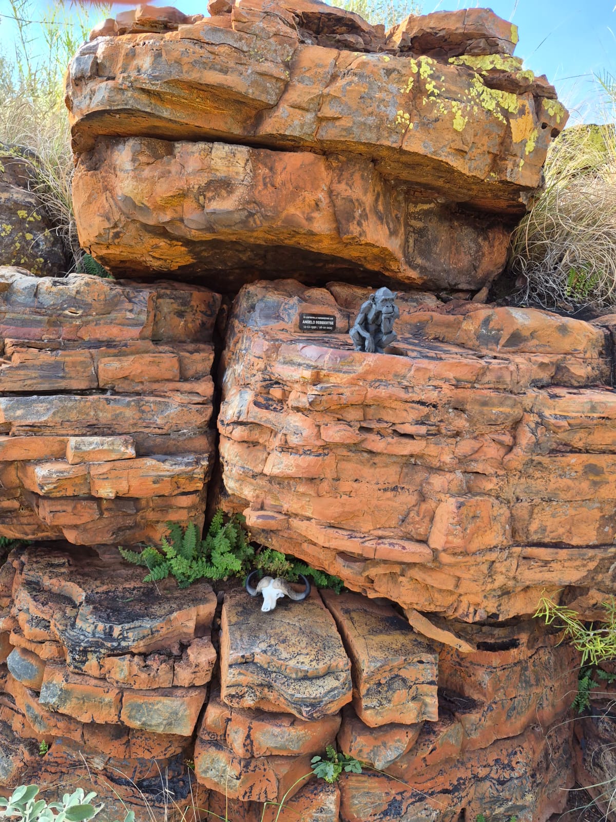 The carved monkey and memorial plaque set into a wide ledge of red sandstone
