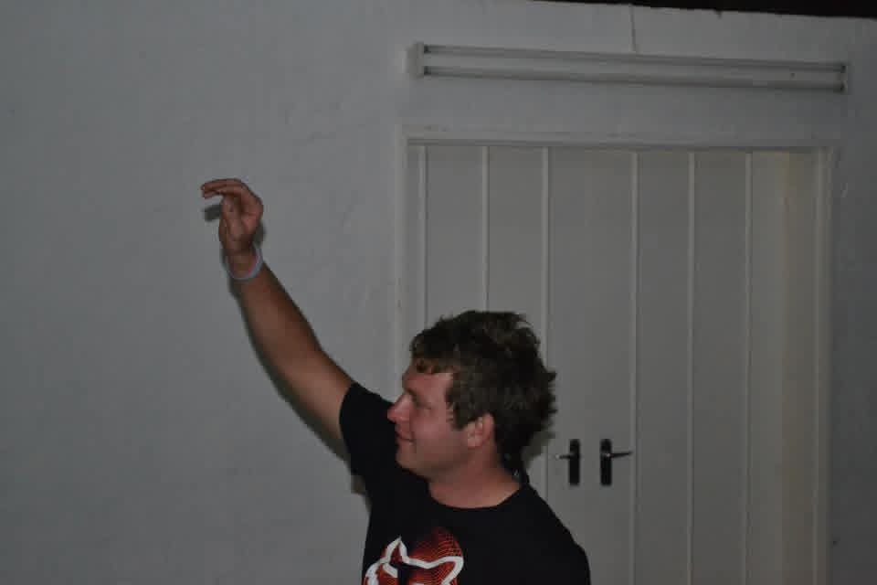 Angelo pointing playfully at the wall during the party