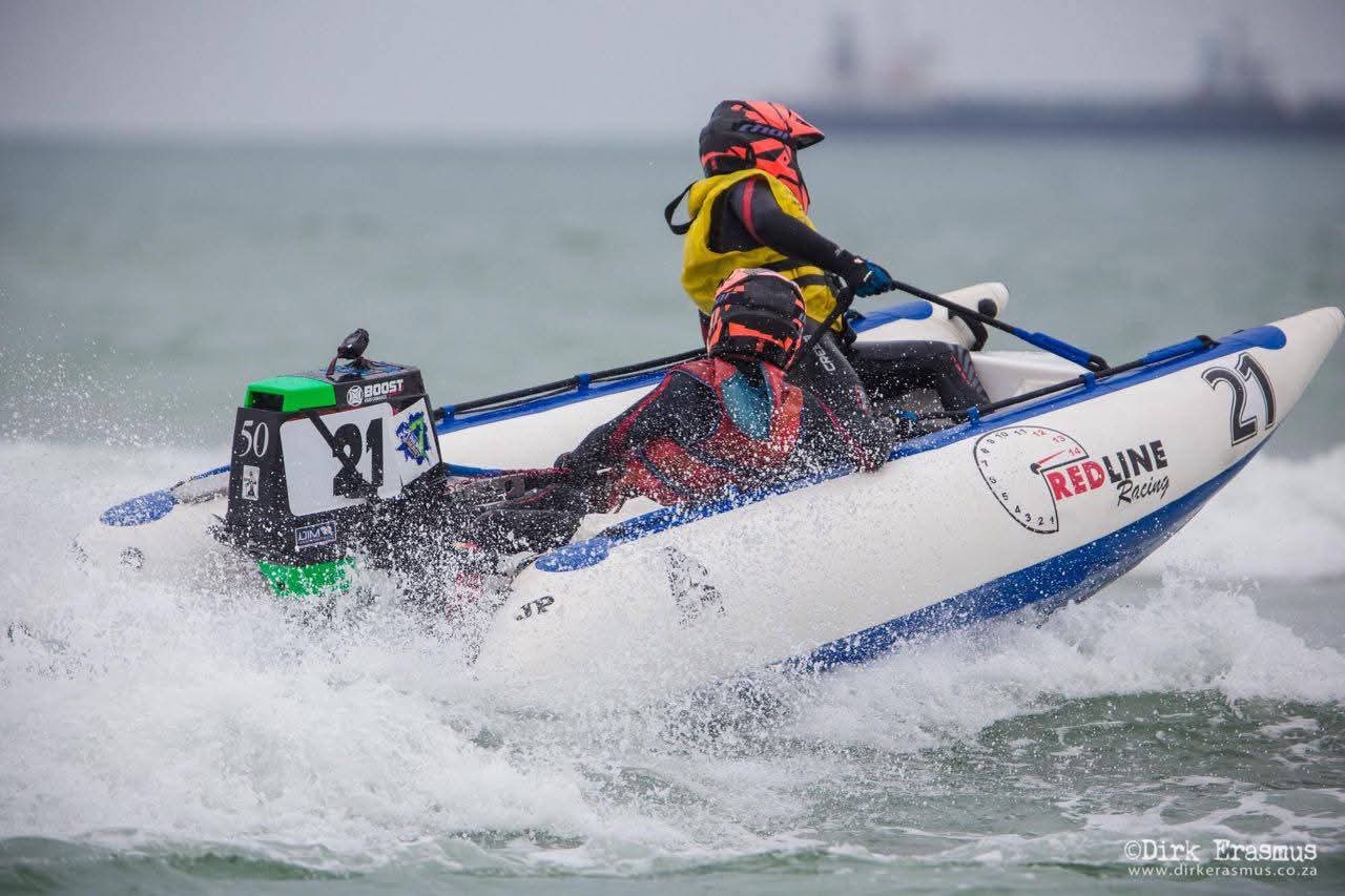 Angelo carving an inflatable racing boat through spray