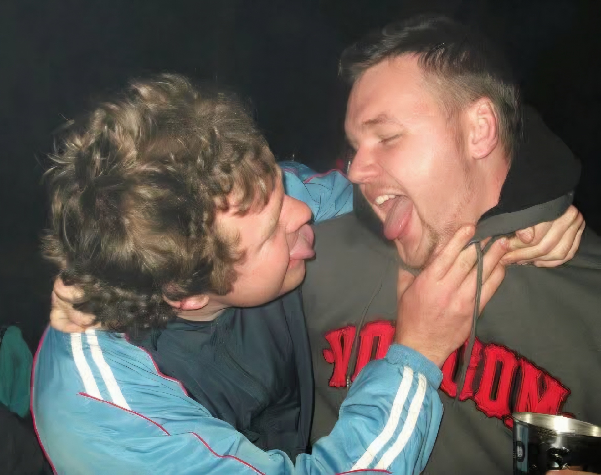 Two friends playfully sticking out their tongues for the camera