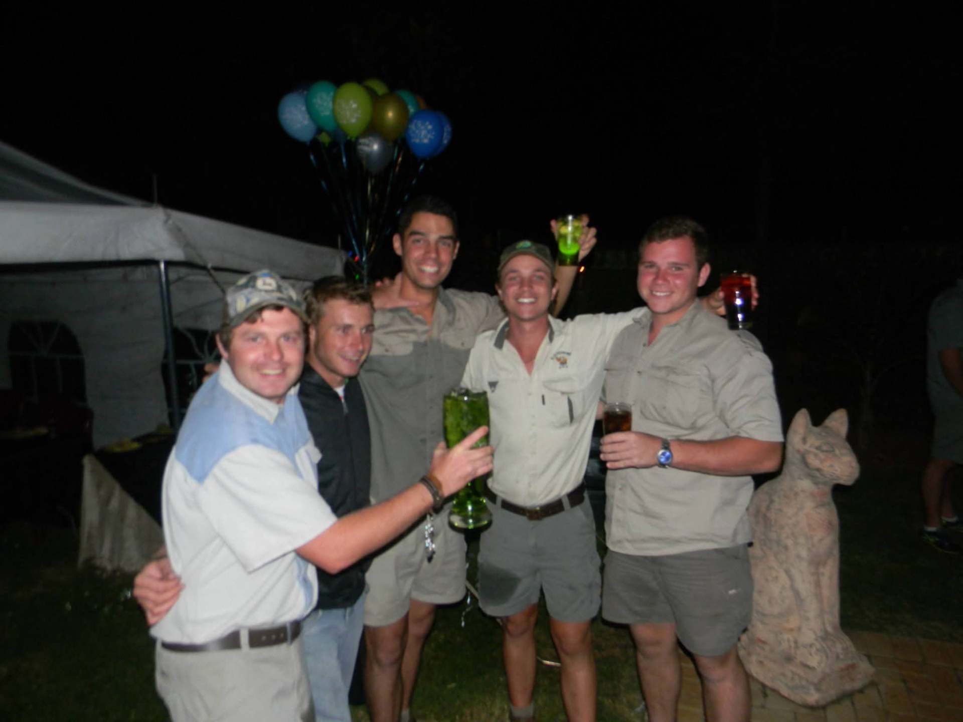 Five friends celebrating at a night-time gathering with balloons