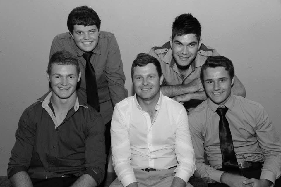 A black and white portrait of five young men including Angelo