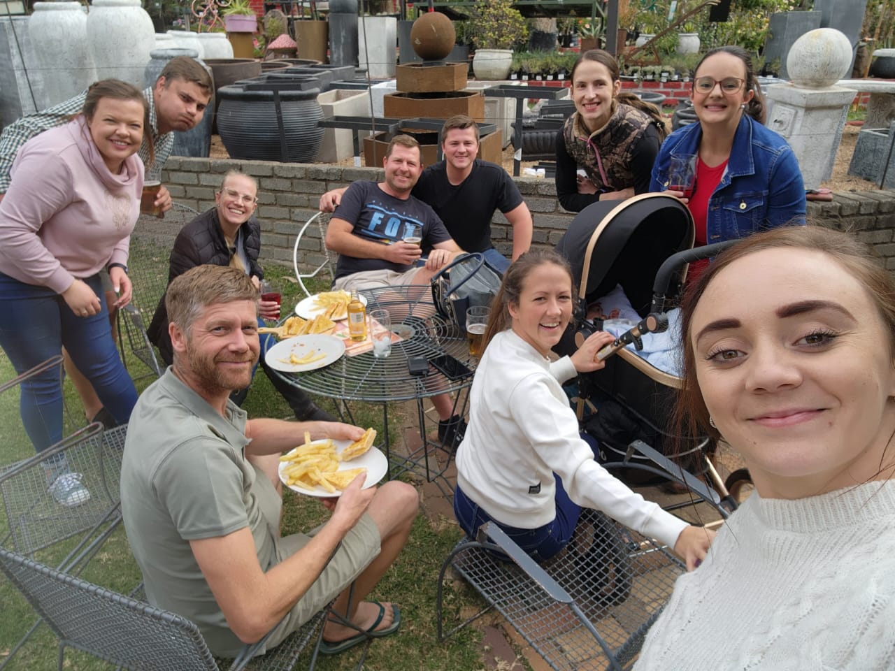 A group of friends sharing fish and chips around a garden table