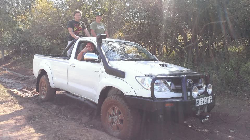 Friends enjoying a woodland drive together in a white bakkie