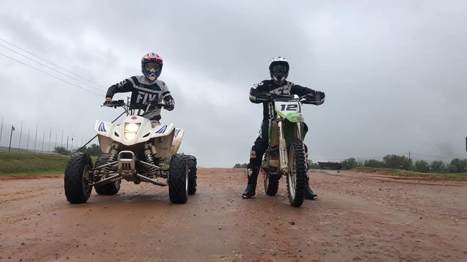 A quad bike and a dirt bike side by side on a wet track