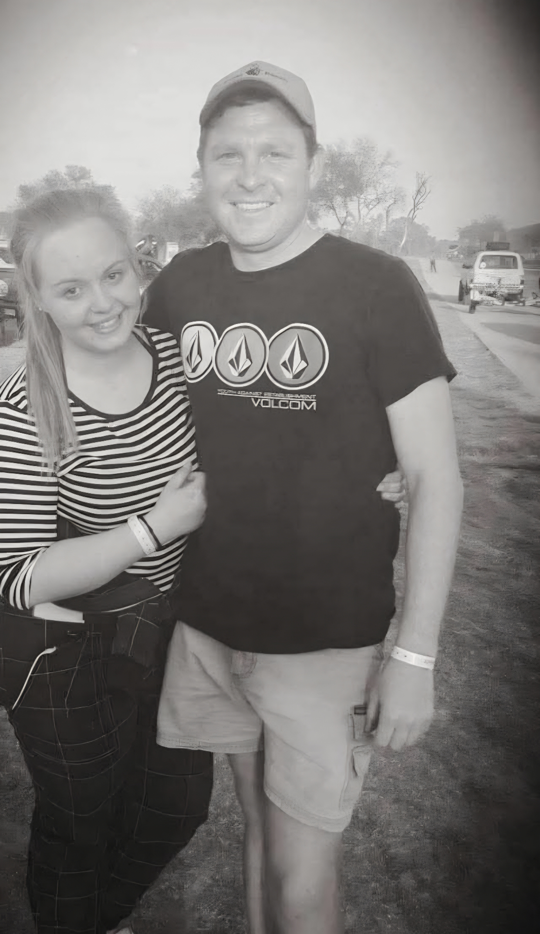 Angelo in a Volcom shirt standing arm in arm with a smiling friend at a festival