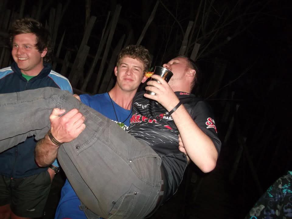 Angelo carrying a laughing friend at a night-time party