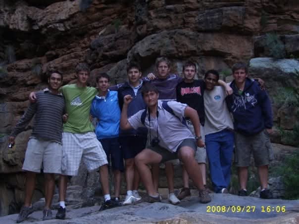 A group of friends posing together on rocky ledges in a gorge