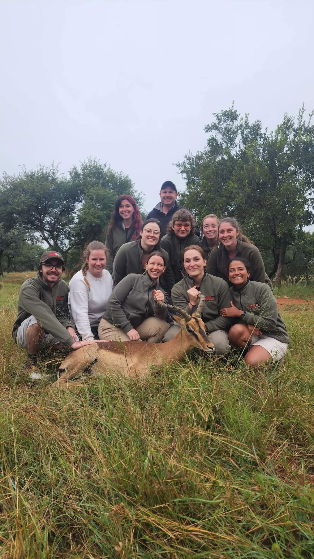 Students Angelo worked with gathered around an antelope in the grass