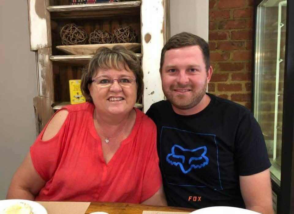 Angelo and his mum smiling together at a restaurant table