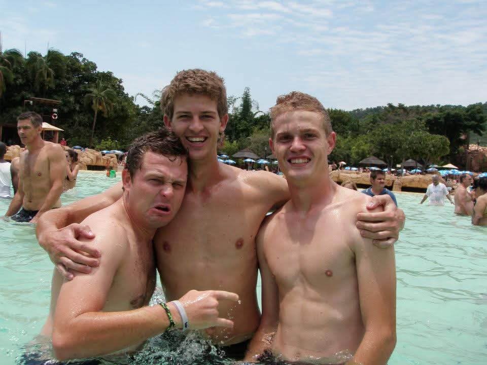 Angelo and two friends laughing together in a water park wave pool