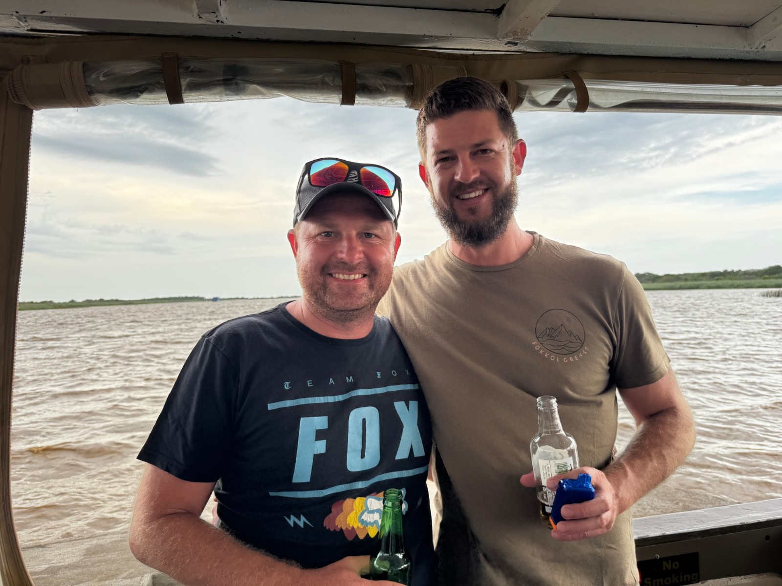 Angelo and his best friend smiling together on a river cruise