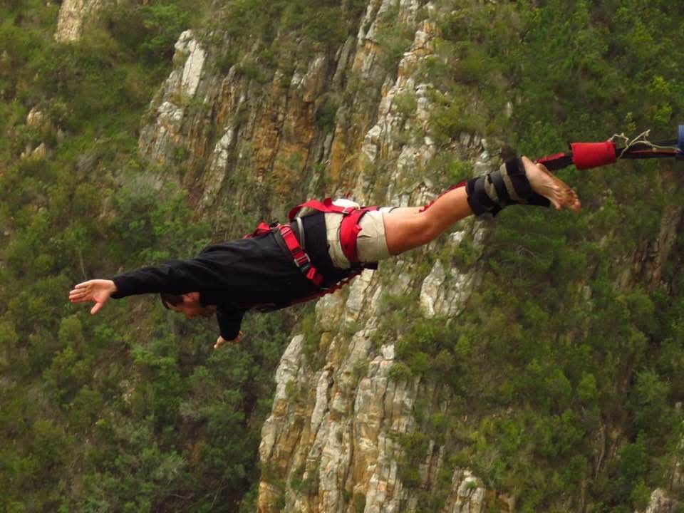 Angelo stretched out in flight with arms wide over the rocky gorge during the bungy jump