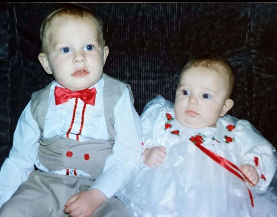 Two babies dressed up in white christening outfits