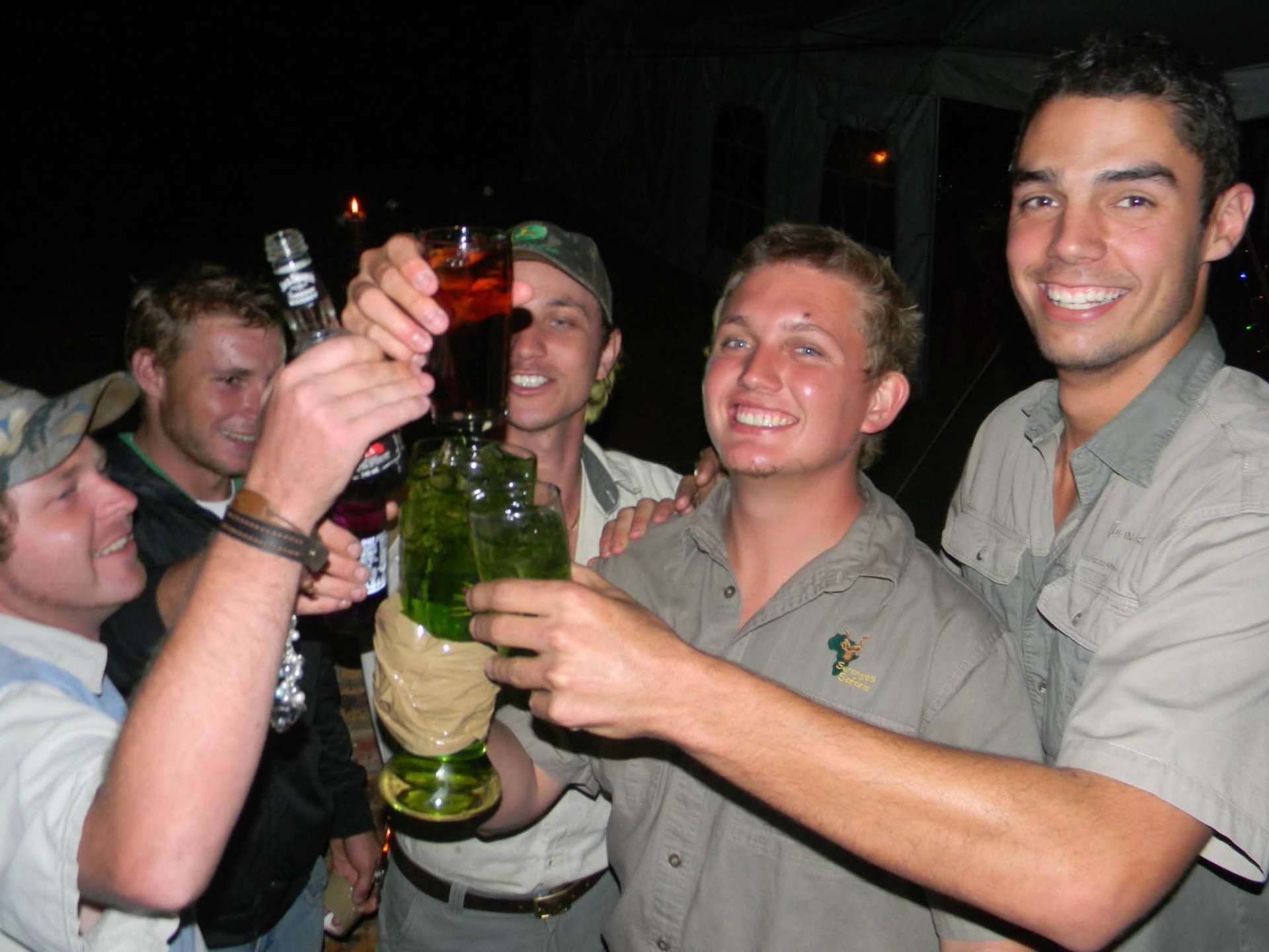 Friends raising their glasses in a toast at night