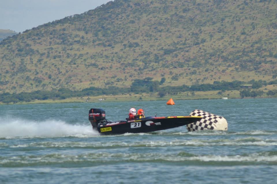 The number 21 boat turning hard around a checkered course buoy