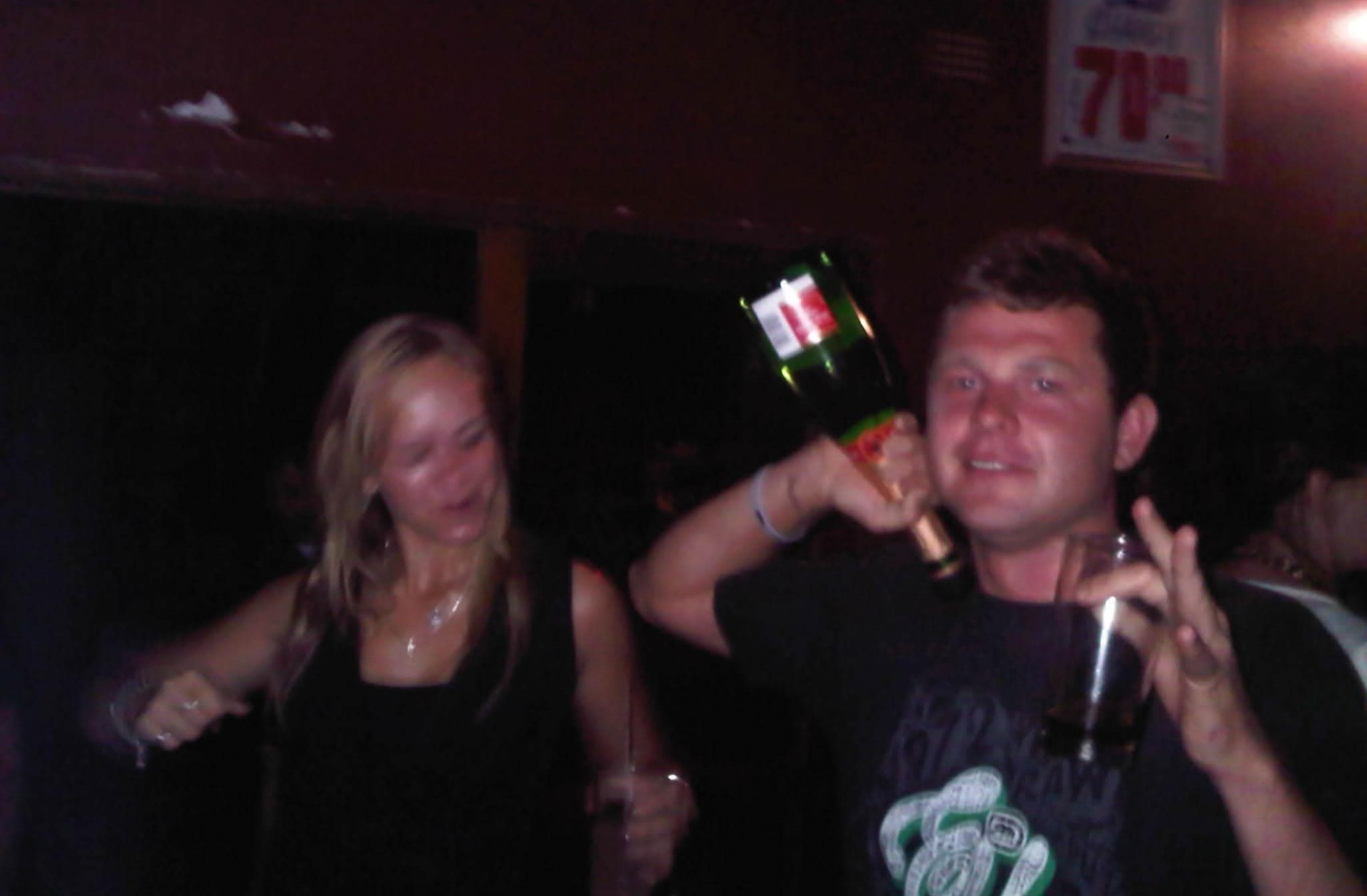 Angelo smiling with a woman at a bar