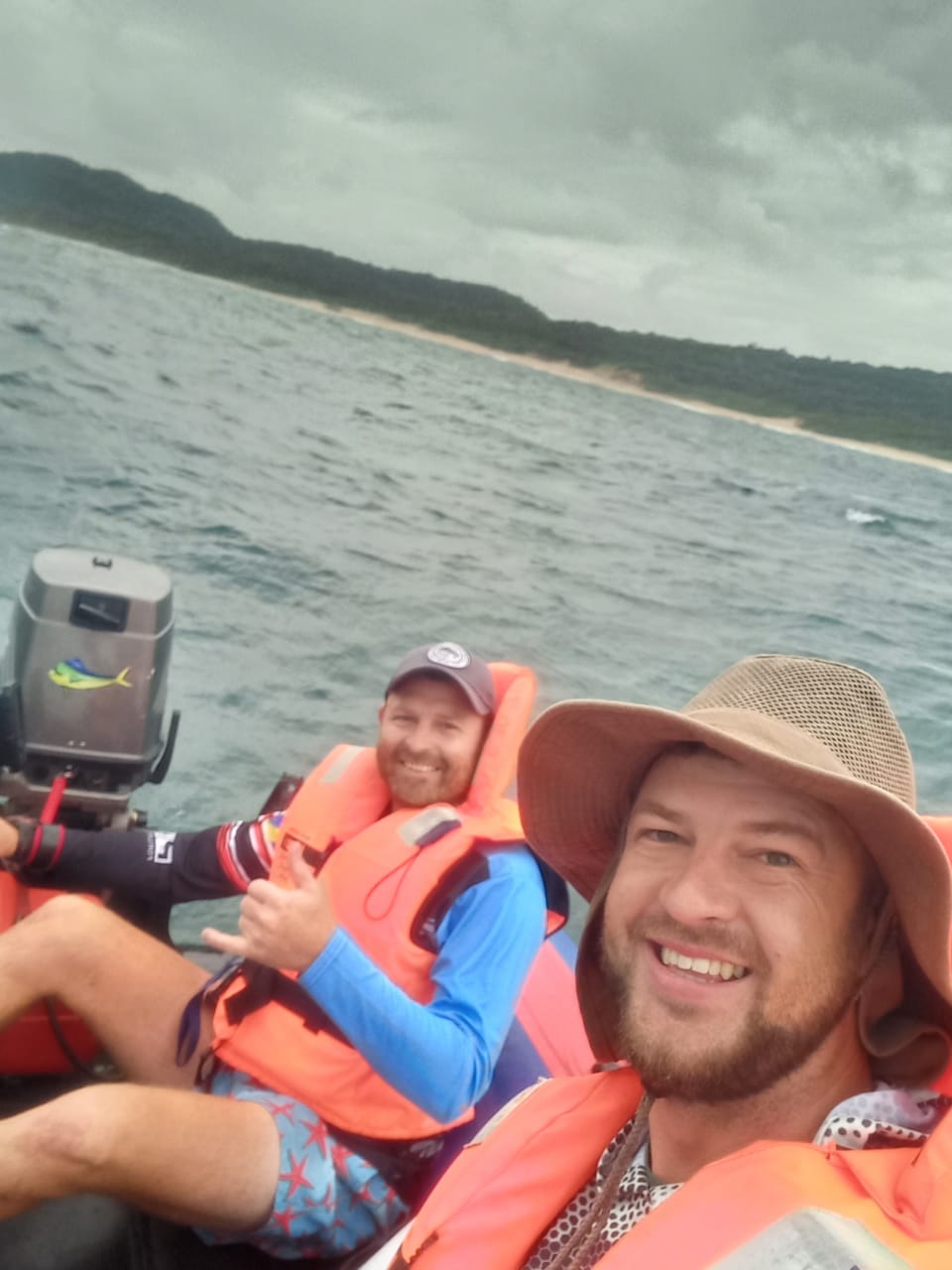 Angelo and his best friend in life jackets on a boat off the coast