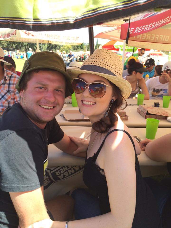 Angelo and a friend smiling together at an outdoor festival
