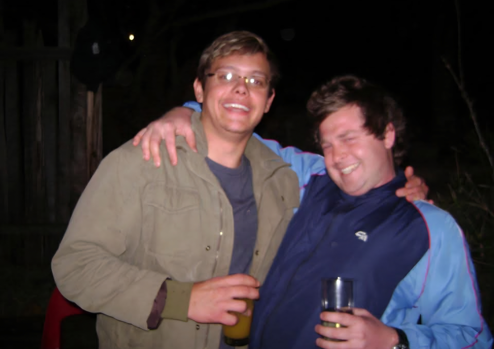 Angelo smiling with a friend at night