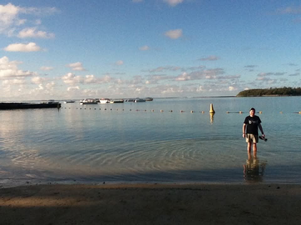 Angelo standing in shallow water at the bay in the evening light
