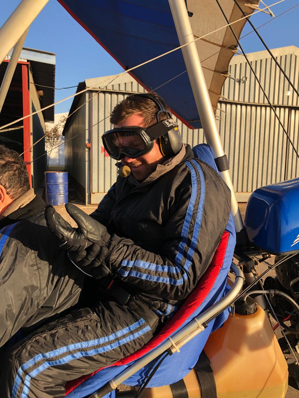 Angelo in headset and goggles in the pilot seat of a microlight aircraft
